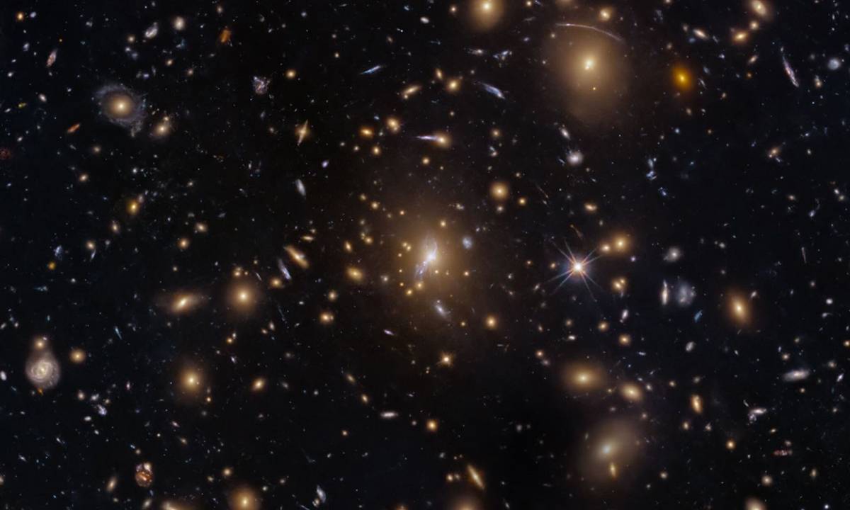 Hubble quan sát một cụm thiên hà từ giai đoạn sớm của vũ trụ nhờ thấu kính hấp dẫn